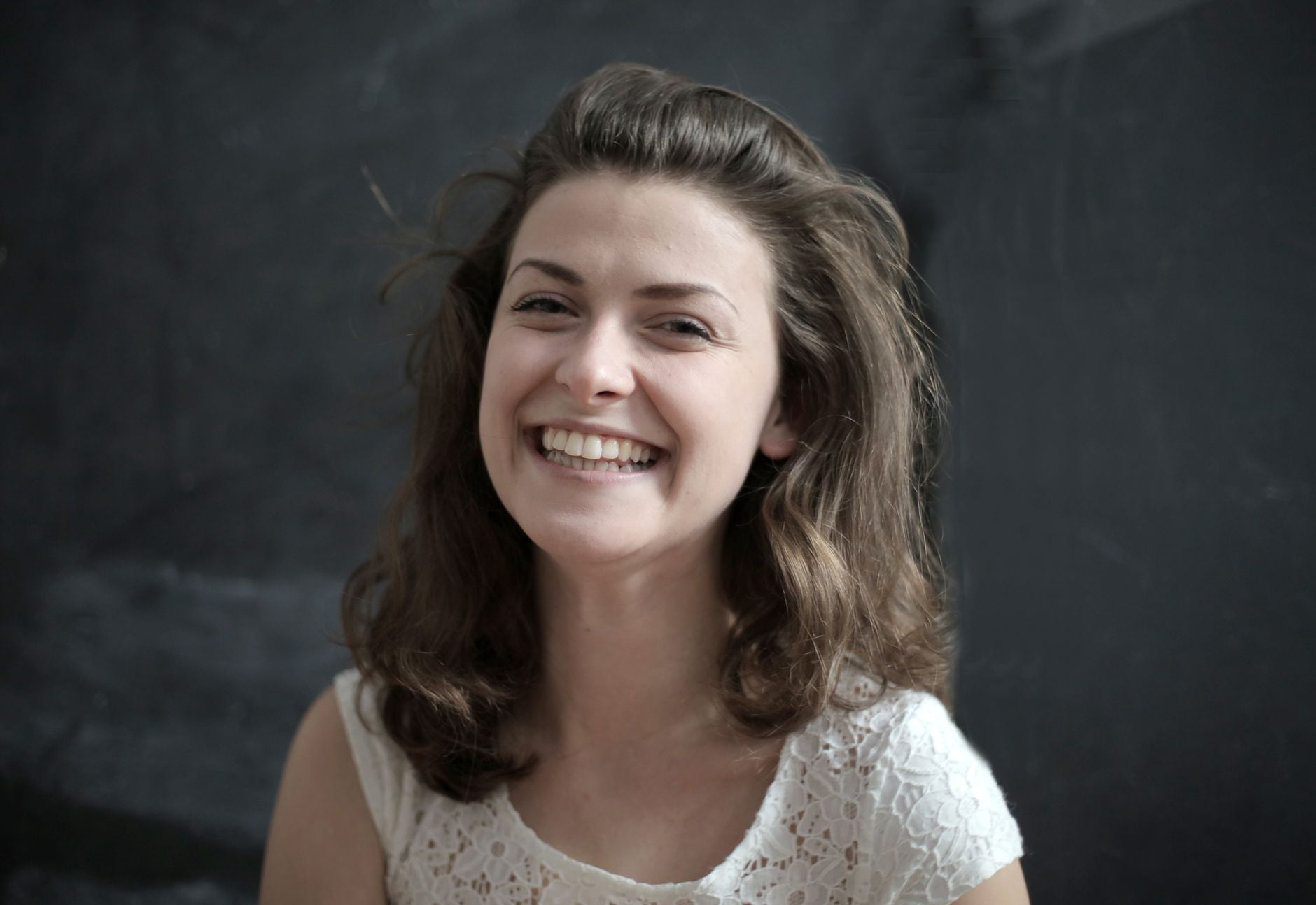 A person smiling, photographed against a dark backdrop