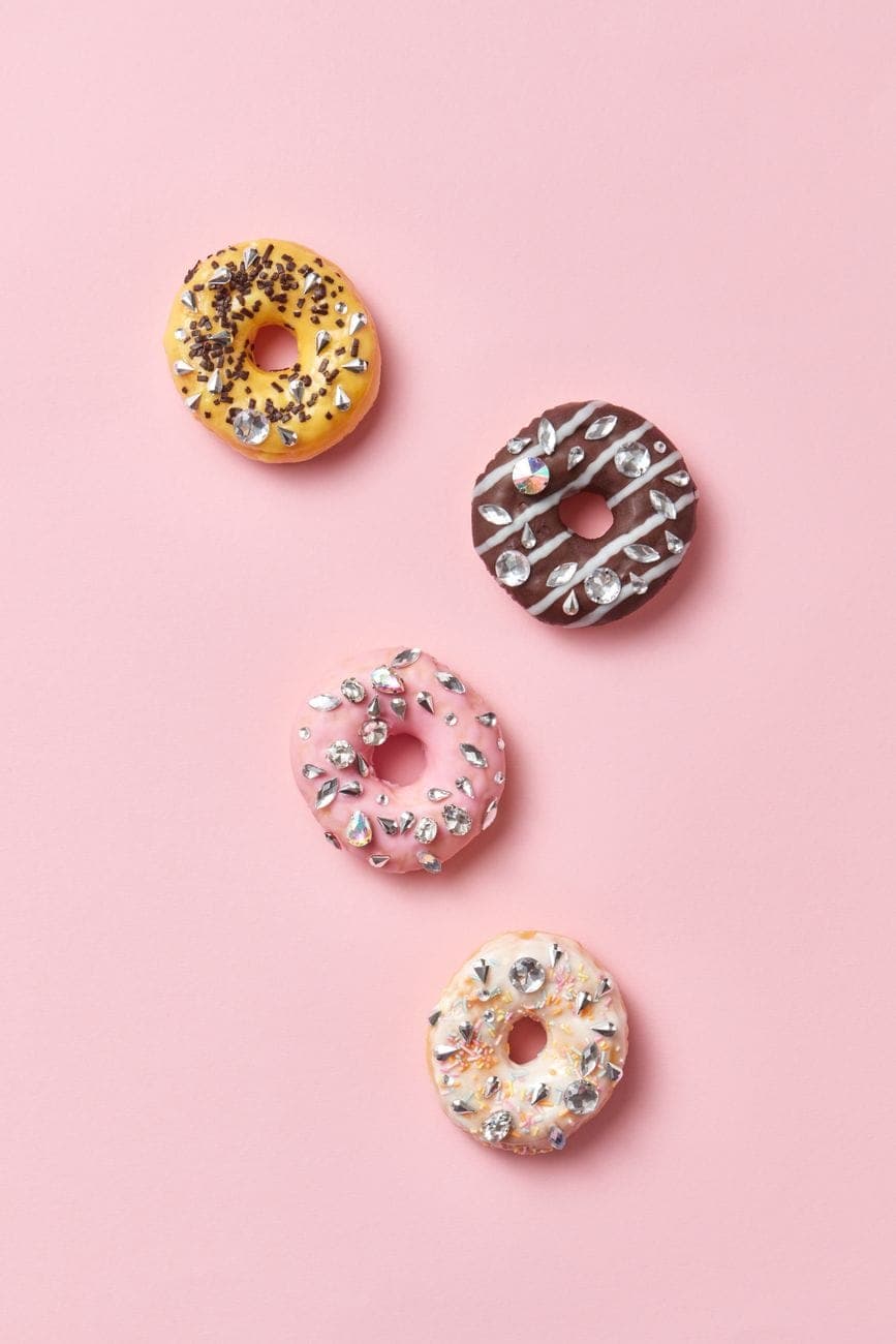 A pink-glazed donut with sprinkles, shot from above