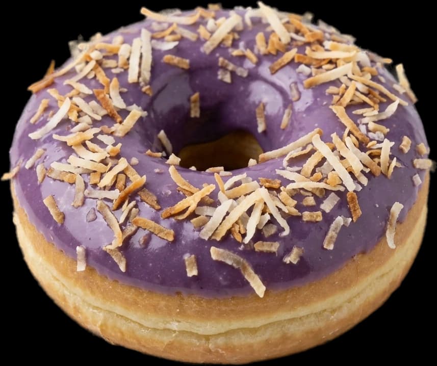 A lilac ube-glazed cake donut scattered with toasted coconut