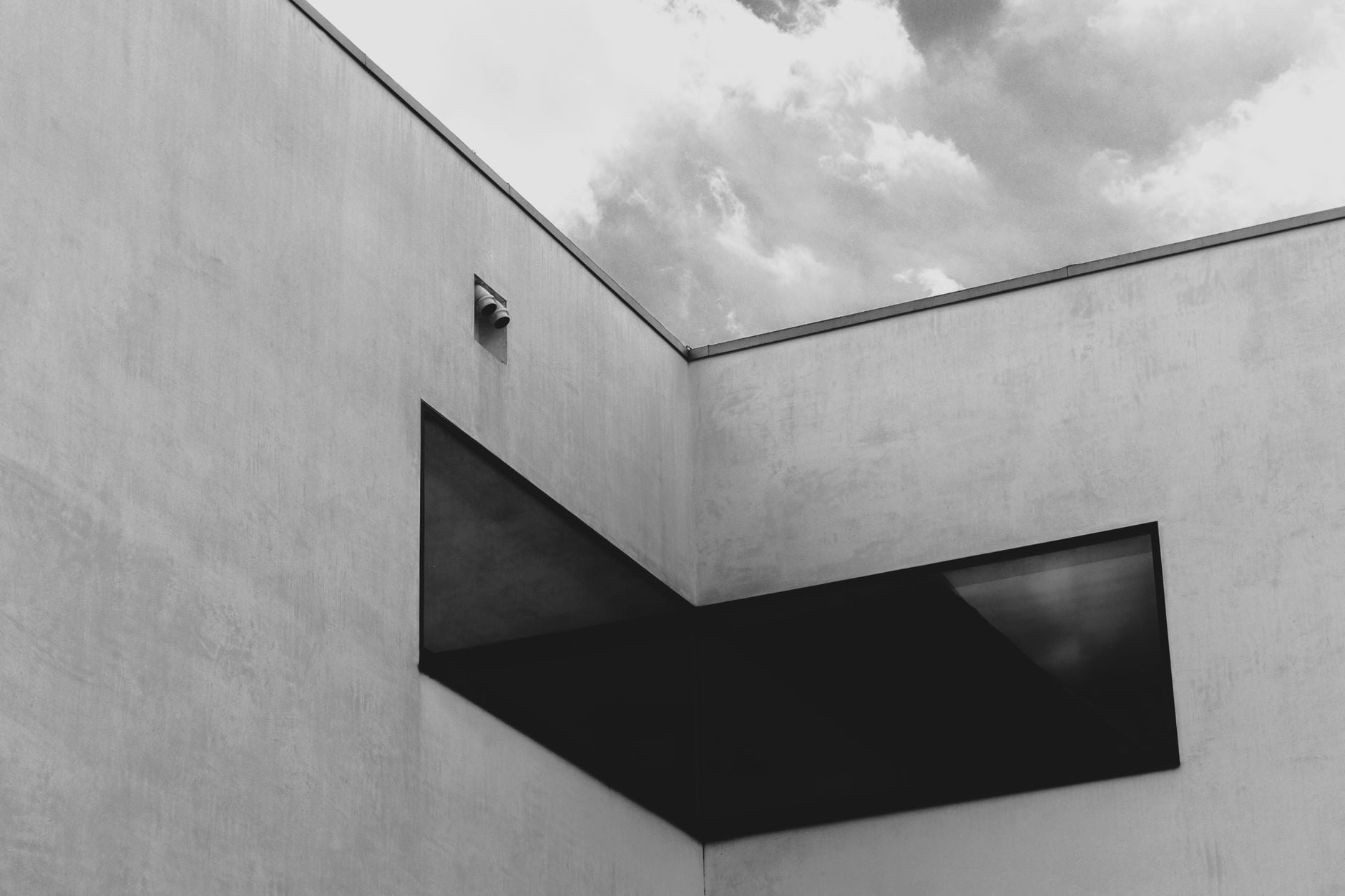 A white minimal corner with an L-shaped window, near monochrome