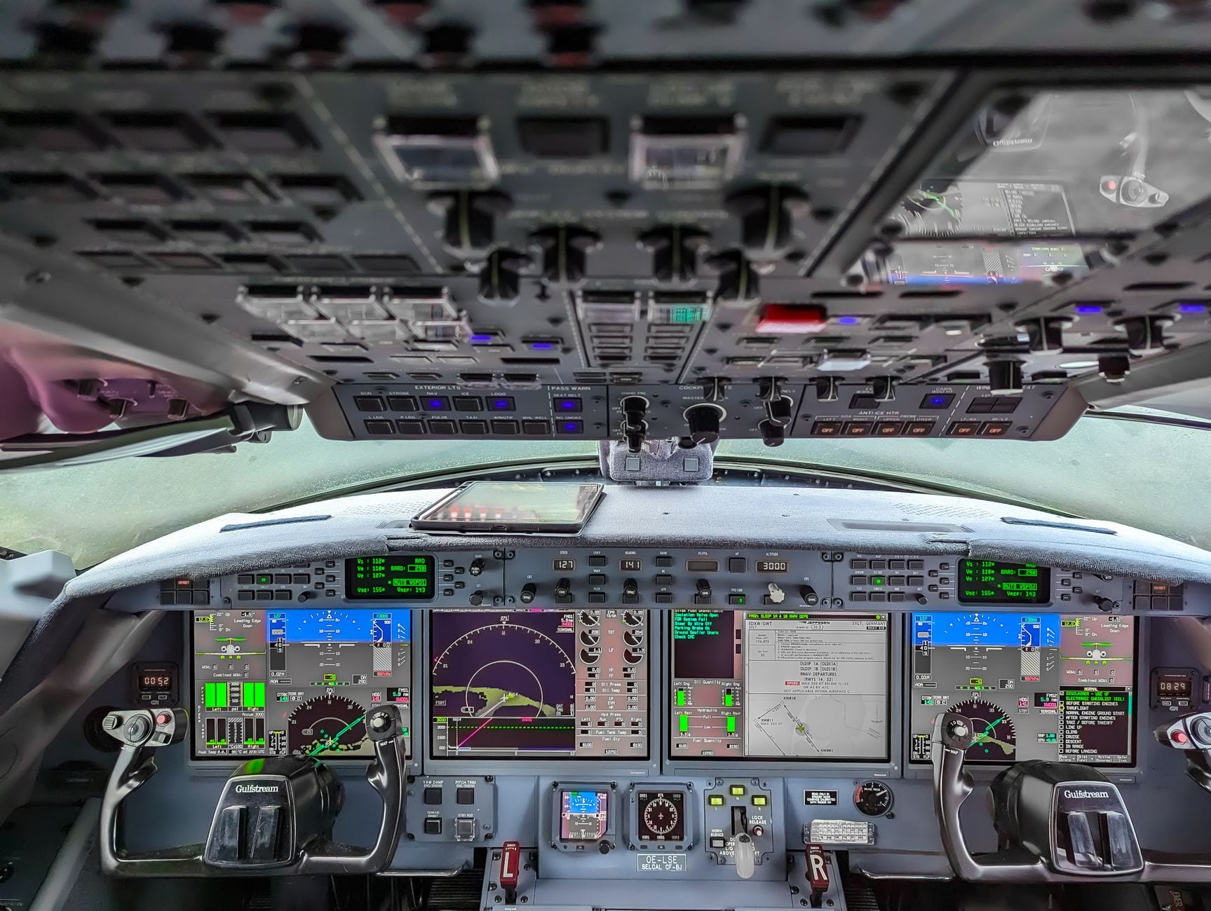 A modern glass cockpit, screens lit