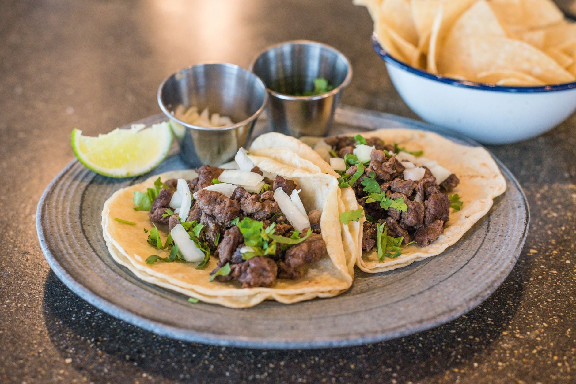 Three carne asada tacos with onion and cilantro